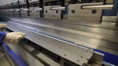 Metal fabrikasında işçi makine koyarak iş parçasına atlayın. Sac ve özel makine bükme aletleri ile çalışan adam. Modern makineleri doğru görevleri gerçekleştirebilirsiniz.