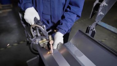 Mekanize el metal izdeliy için Punta kaynak kullanarak çalışır. Bir metal, onun görev nokta kaynağı ile bir fabrikada çalışan ve lehimleme Muzhchina.