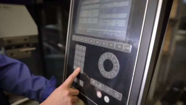 Arbetstagaren pressar knappar på panelen av verktyget maskin med numeriska programmerad styrning. Ingenjören konfigurerar program för drift av maskinen. — Stockvideo