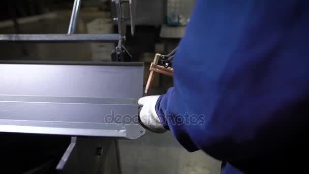 Travailler à l'aide de la main mécanisée pour le soudage par points de l'izdeliy.Muzhchina métallique travaillant dans une usine avec un métal, son devoir de soudage par points et de soudage .