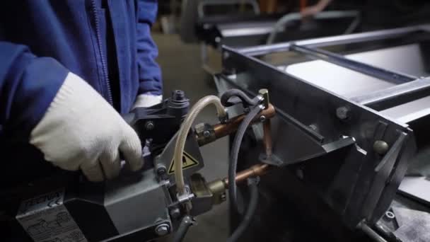 Travailler à l'aide de la main mécanisée pour le soudage par points de l'izdeliy.Muzhchina métallique travaillant dans une usine avec un métal, son devoir de soudage par points et de soudage .