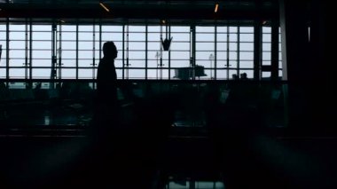 Havaalanı. Geçen insanlar. Panoramik pencerelere. Bavul yolcu uçuşları için gidin. Yakındaki bekleme odası.