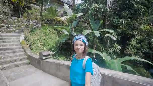 Młoda kobieta relaksujący na egzotycznej wyspie i pędy selfie wideo za pomocą laski. Dziewczyna Pokaż starych budynków, górskiej rzeki i pięknej przyrody, która otacza ją. — Wideo stockowe