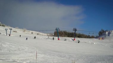 Kayak pisti görünümünü. Açık kış ve soğuk hava, sıcak giyinmiş kadar insanlar çalışırken Kayak Snowboard. Ağaçlar ormandan uzak içinde gördüğünüz.
