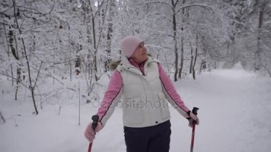 Enerjik kadın Nordic ormanda egzersiz sahip. Mutlu kadın atlet Kış Doğa açık havada yolda Kayak Polonyalılar ile ayakta ve memnun seyir çevrede yürüyüş ve sağlıklı yaşam tarzı.