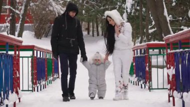 Baba ve anne oğlu ile aşağı bir arka sokakta bir kış parkı bebek elele yürümek. Anne bebeği için bir emzik düzeltir. Aile onun hafta sonları birlikte geçiriyor.