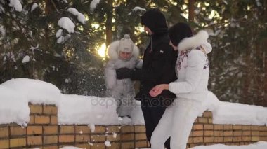 Genç anne düştü Papa tarafından desteklenen küçük çocuğunu tezahürat kadar çalışıyor. Kadın kar atar ve sonra kar tarafına uçar. Mutlu aile ile kış parkta vakit