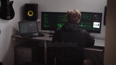Hacker kesmek veritabanı için çeşitli bilgisayar verilerini toplar. Birden çok monitör ve küçük bir oda bir dizüstü bilgisayar için çalışan özel eğitimli genç adam.