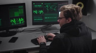 Deneyimli hacker siber saldırılar hesaplarına para çalmak için büyük şirketlerin sunucusunda gerçekleştirir. Yasadışı bir gizli ofis içinde birden çok bilgisayar için aynı zaman iş yerinde gözlüklü adam.