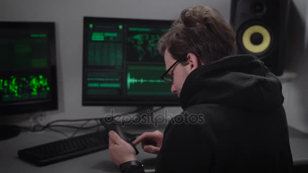 Internet fraudster reflashing stolen smartphone to obtain user data. Hacker looks at the computer screen and reads with him a special code. — Stock Video