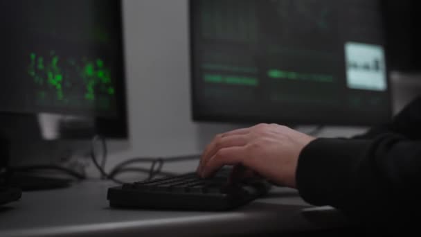 Un pirate se prépare à une cyberattaque dans la salle informatique souterraine. Un homme à un rythme rapide entre dans l'information. Sur moniteurs les informations sur les préparatifs de l'attaque de pirate . — Video