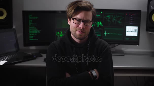 Haker villain złośliwe oczy gdy kamera porusza się na niego, na tle pracy monitorów komputerowych. To specjaliści po atakach na wielu serwerach na całym świecie. — Wideo stockowe