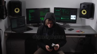 Kukuletalı hacker Oda bir sandalyede oturan ve ağ kesmek için ön ödeme hesap siyah giysili. Para kontrol ettikten sonra adam cebine koyar ve siber suç yapmak için bilgisayarı kapatır.