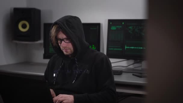 Un hacker dans la salle informatique. L'homme avec des lunettes et un ordinateur portable sur une main essayant de pirater des informations provenant de bases étrangères. La salle est équipée de tous les ordinateurs les plus .