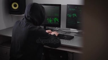 Arkadan görünüşü bir kapüşonlu kızgın hacker'ı olan siyah cyber banka ağ ve failuring işlemi saldırı yapma. Ağırlaştırılmış adam klavye masanın üstüne atma ve yumruklarını ile çarpıcı.