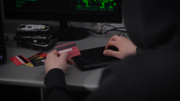 Η εταιρεία χάκερ. Ένας χάκερ ετοιμάζεται για το σπάσιμο των χρηματοοικονομικών λογαριασμών. Ένας άνθρωπος με ταχύ ρυθμό εισάγει πληροφορίες με ξένες πιστωτικές κάρτες σε υπολογιστές. Οθόνες πληροφοριών — Αρχείο Βίντεο