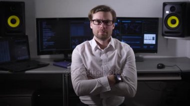 Kollarını çapraz bir adam görünümü. Siyah çerçeveli gözlük önünde el smartwatches üzerinde beyaz bir gömlek giymiş. Bir kişi bir komisyoncu veya office işçi arkasında birkaç ekranı olabilir