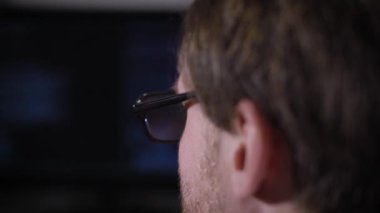 Orta yaş bir adam yakın bir kadeh. Gözleri siyah çerçeveli gözlüklü yüzünde, anız görebilirsiniz. Muhtemelen o programcı, onun işyerinde, el Parlatıcı saatler içinde oturan