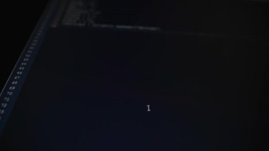 Bilgisayar sınıfı. Bilgisayarda işleri yapılmaktadır. Monitörde bir kod giriş süreci vardır. Program kodu sadece bir şişirme ve programlama Dil sembolleri olduğunu.