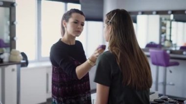 Yüzüne yüzüne dışarıda tutmak için kelepçeler kaldırıldı uzun kumral saçlı, sessiz bir modeli profesyonel bir sünger yardımıyla kendine güvenen Vakfı stüdyoda çalışan, makyöz, fırsatlar