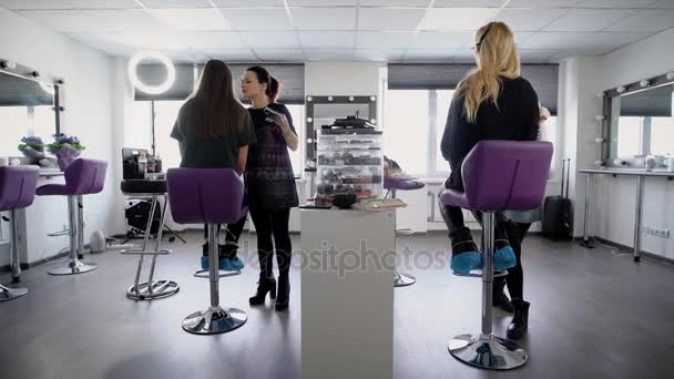 Estudantes da faculdade tentando fazer sua primeira maquiagem sobre a formação prática em salão de beleza profissional. Meninas jovens aprendem uma nova profissão na indústria da moda . — Vídeo de Stock