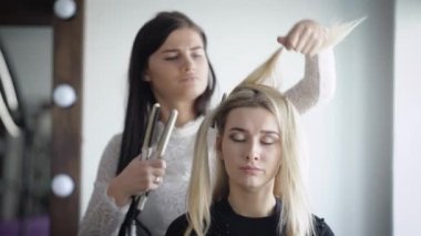 Aptal ama çok çekici sarışın saç özel salonların kullanýlýyor ile hizalamak için bir güzellik salonu için geldim. Uzman çok dikkatli bir şekilde saç modeli müvekkilinin için yapar..