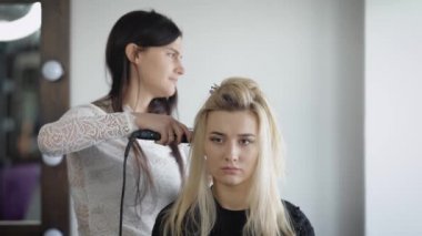 Korkutma yeni model demir bukle yapmak için saç kökünde tutan Kuaför, saçlara oturur. Bu ilk model, o fotoğraf pozlar nedeniyle geçmekte böyledir