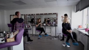 Lüks Güzellik Salonu görüntüsü. Üç model salonda oturmuş ve iki profesyonel uzmanlar birlikte istemciler ve fotoğrafçılık için onları hazırlamak için görüntüler oluşturmak için çalışıyoruz.