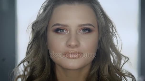 Nahaufnahme. schönes Mädchen. die Blondine ist bereit für eine Party. der Frau sehr schönes und natürliches Make-up gemacht, auf den Lippen ein leichter Lipgloss. ein Make-up im Nude-Stil. — Stockvideo