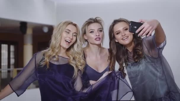 Tre amiche felici stanno facendo divertenti selfie sorridenti felicemente. Sexy ragazze chic stanno celebrando l'anniversario e la partecipazione alla festa di compleanno. Le signore si rilassano e si godono il tempo insieme . — Video Stock