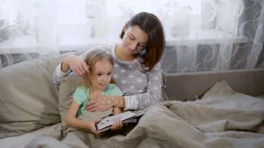 Küçük kız giymiş mavi bir gömlek ve çizgili pantolon, o son zamanlarda işaretleri yapmış onun anne şekli gösterir. Anne kızı çizim başarı zevk hafifçe sarı saçlı kız dokunmadan