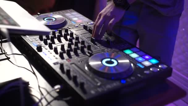 En el marco de los DJs manos en un club nocturno. La fiesta está en pleno apogeo y el disc jockey de moda pone pistas y canciones modernas para el público . — Vídeo de stock