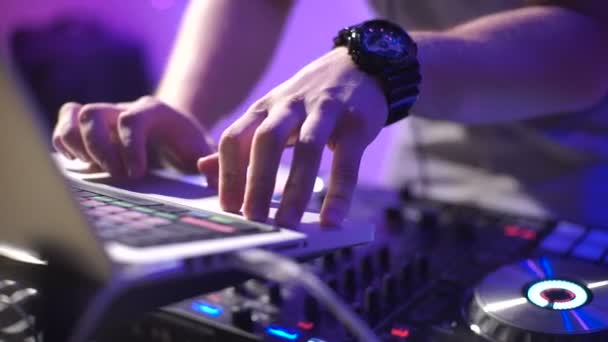 In the frame the DJs hands in a nightclub. The party is in full swing and the fashionable disc jockey puts modern tracks and songs for the public. — Stock Video