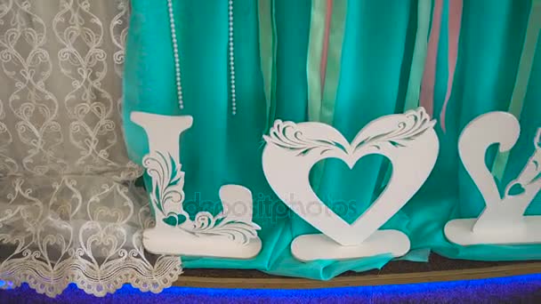 Travesseiro azul na cadeira branca e palavra de madeira AMOR. Valentine ou fundo do dia do casamento. Conceito de amor . — Vídeo de Stock