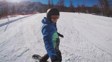 Kışın kullanıyor. Bir adam bir dağ tatil beldesinin karla kaplı yollar bir snowboard üzerinde inişli çıkışlı olduğunu. Adam kendini aşırı bir kamera kapalı alır.