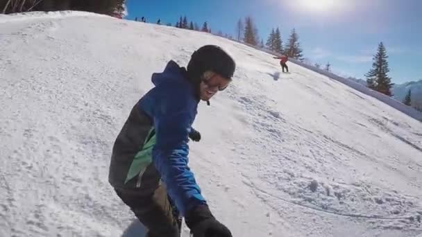 Esqui nos Alpes no inverno. Um homem está rolando em um snowboard nas trilhas cobertas de neve de um resort de montanha. O tipo descola-se numa câmara extrema. . — Vídeo de Stock