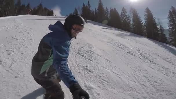 在冬季在阿尔卑斯山滑雪。一个人滚动在滑雪板上的山庄雪覆盖的小径上。这个家伙把自己起飞极端的相机上. — 图库视频影像