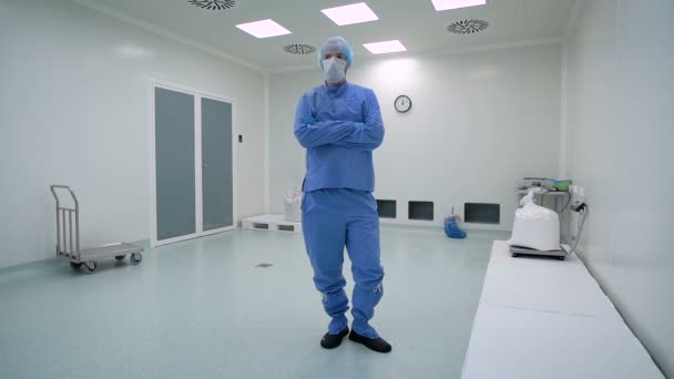 Een man die werkt in een cleanroom, farmaceutische onderneming. Specialist in een beschermend pak, een masker, handschoenen en bril. — Stockvideo
