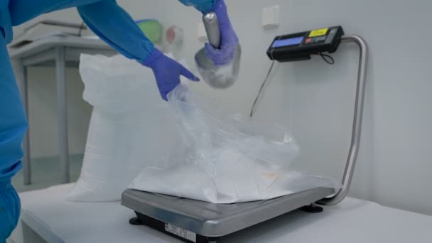 Pharmaceutical production. Working Party forms a chemical ingredient by weight makes for a drug. White powder is poured into a bag on electronic scales. — Stock Video