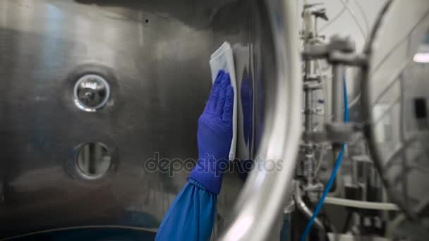 Instalación de tanques de equipos de tecnología farmacéutica para la preparación, limpieza y tratamiento de agua. El trabajador en un traje protector hace la limpieza del tanque con trapos humedecidos con alcohol — Vídeos de Stock