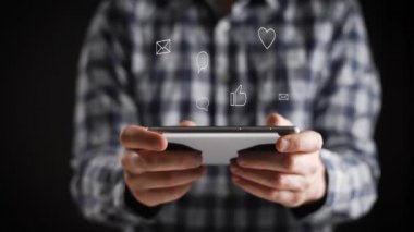 Kavramı, dijital online yaşam ve sosyal ağlar. Bir gömlek genç bir adam onun smartphone onun hesapları görüntülemek için kullanır. Animasyon şovları seviyor, yorum, abonelikler, reposts.