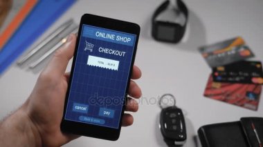 Bir mağaza receipe smartphone uygulaması ile ödeme. İçinde çerçevesinde adamın elleri, bir çevrimiçi mağaza üzerinden Internet ve onun smartphone alımları için bir kişi öder. Giyim için onay