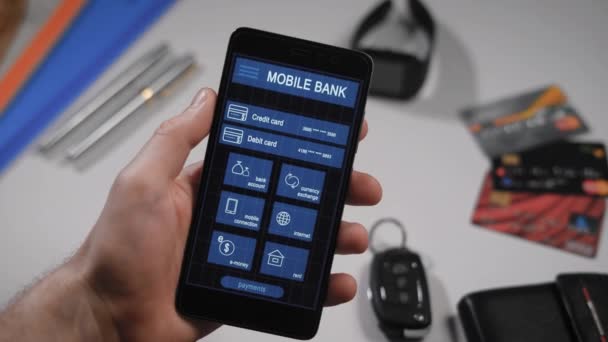 Licznik płatności za pośrednictwem bankowości mobilnej aplikacji na smartfonie. Człowiek przekazuje pieniądze z jego karty kredytowej do innej osoby. — Wideo stockowe