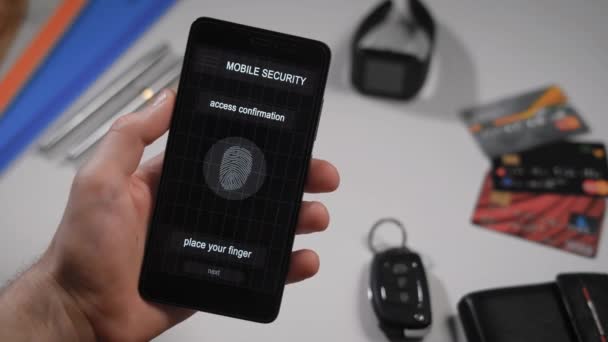 Accesso rapido e sicuro al tuo account con la scansione delle impronte digitali. L'applicazione sullo smartphone, l'uomo applica il dito allo scanner, il programma consente l'accesso . — Video Stock