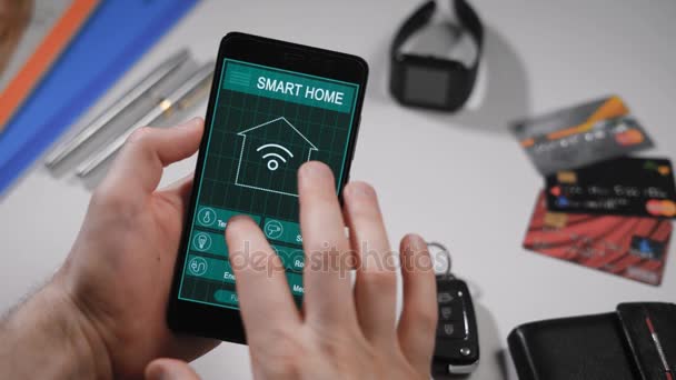 Smart home, applicazione al telefono. Un uomo gestisce vari parametri della sua casa da uno smartphone. Le tecnologie Smart Home consentono di controllare illuminazione, temperatura, sistemi di sicurezza — Video Stock