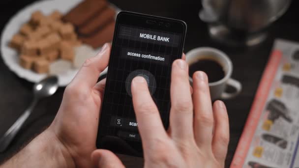 Accès Internet sûr et rapide, services bancaires mobiles avec balayage des doigts. L'application sur le smartphone, l'homme applique son doigt au scanner, le programme permet d'accéder aux comptes . — Video
