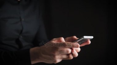 Kavramı, dijital online yaşam ve sosyal ağlar. Bir işadamı bir gömlek onun smartphone onun hesapları görüntülemek için kullanır. Etkileyici atış, karanlık bir odada bir adam şık bir telefon tutarak