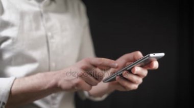 Kavramı, dijital online yaşam ve sosyal ağlar. Bir işadamı bir gömlek onun smartphone onun hesapları görüntülemek için kullanır. Etkileyici atış, karanlık bir odada bir adam şık bir telefon tutarak