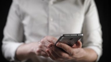 Kavramı, dijital online yaşam ve sosyal ağlar. Bir işadamı bir gömlek onun smartphone onun hesapları görüntülemek için kullanır. Etkileyici atış, karanlık bir odada bir adam şık bir telefon tutarak