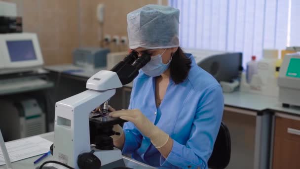 Laboratorium szpitalnym z wyposażeniem i mikroskopu. Portret kobiet student lub pół cut lekarka. Specjalista badań próbek biologicznych w kręgosłup mikroskopy. — Wideo stockowe